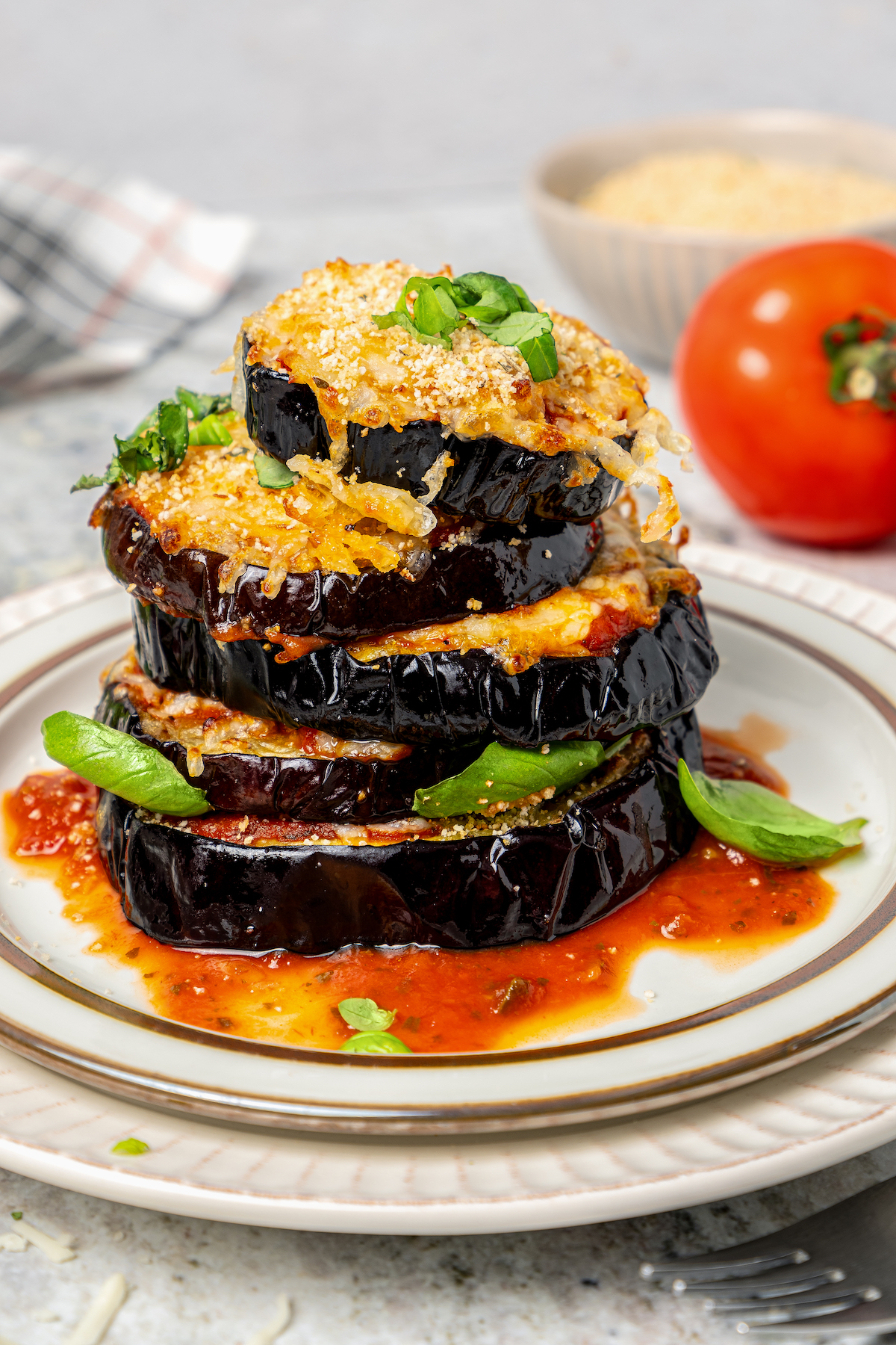This saucy air fryer eggplant parmesan recipe with fresh mozzarella is the perfect veggie appetizer for dinner parties. Cheesy air fryer eggplant parmesan on a plate.