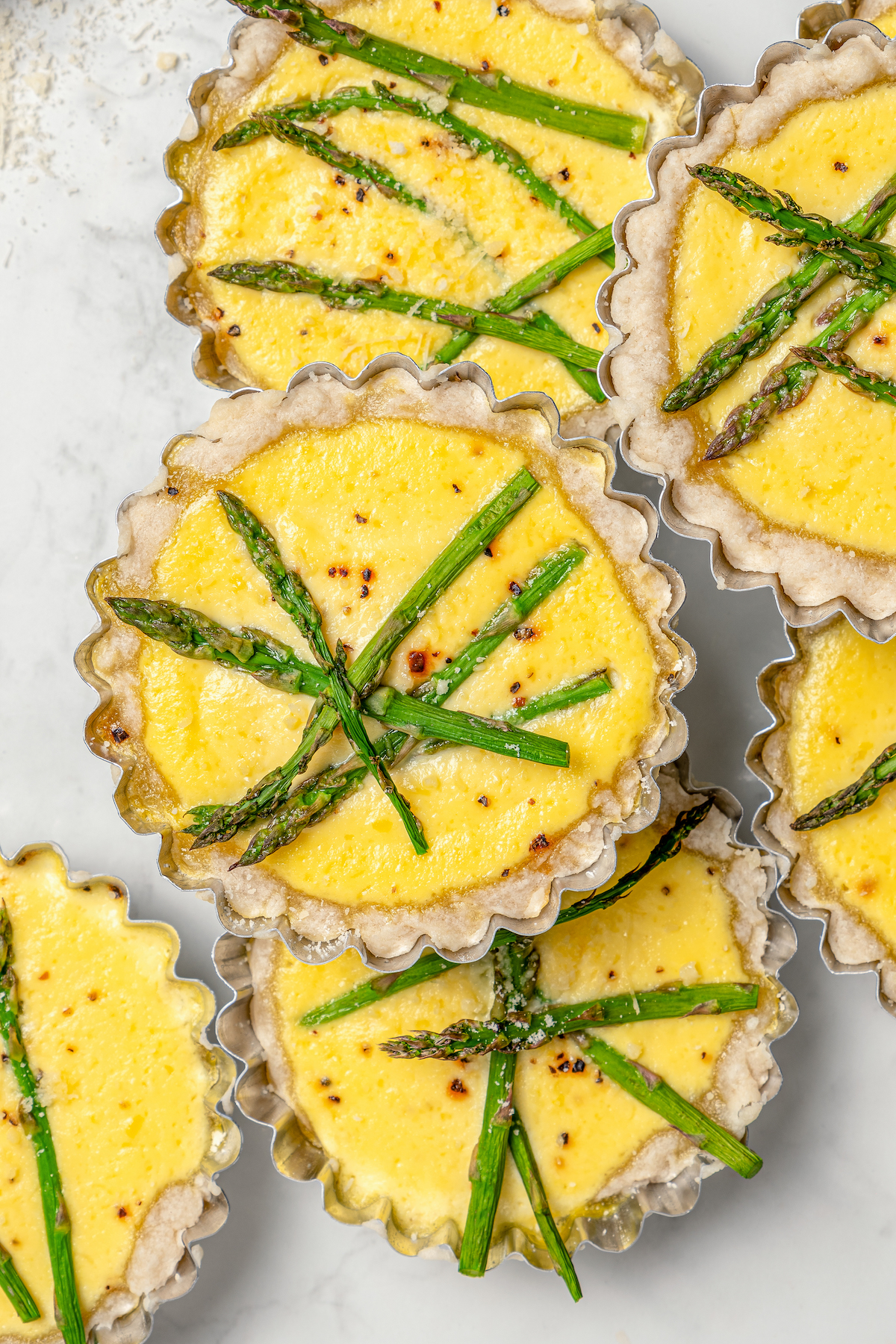 This asparagus tartlets recipe with zesty parmesan custard and buttery crust is an easy way to impress guests for brunch. Several asparagus tartlets with lemon-parmesan curd filling.
