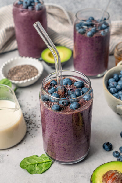 Blueberry superfood smoothie topped with fresh blueberries in a serving glass.