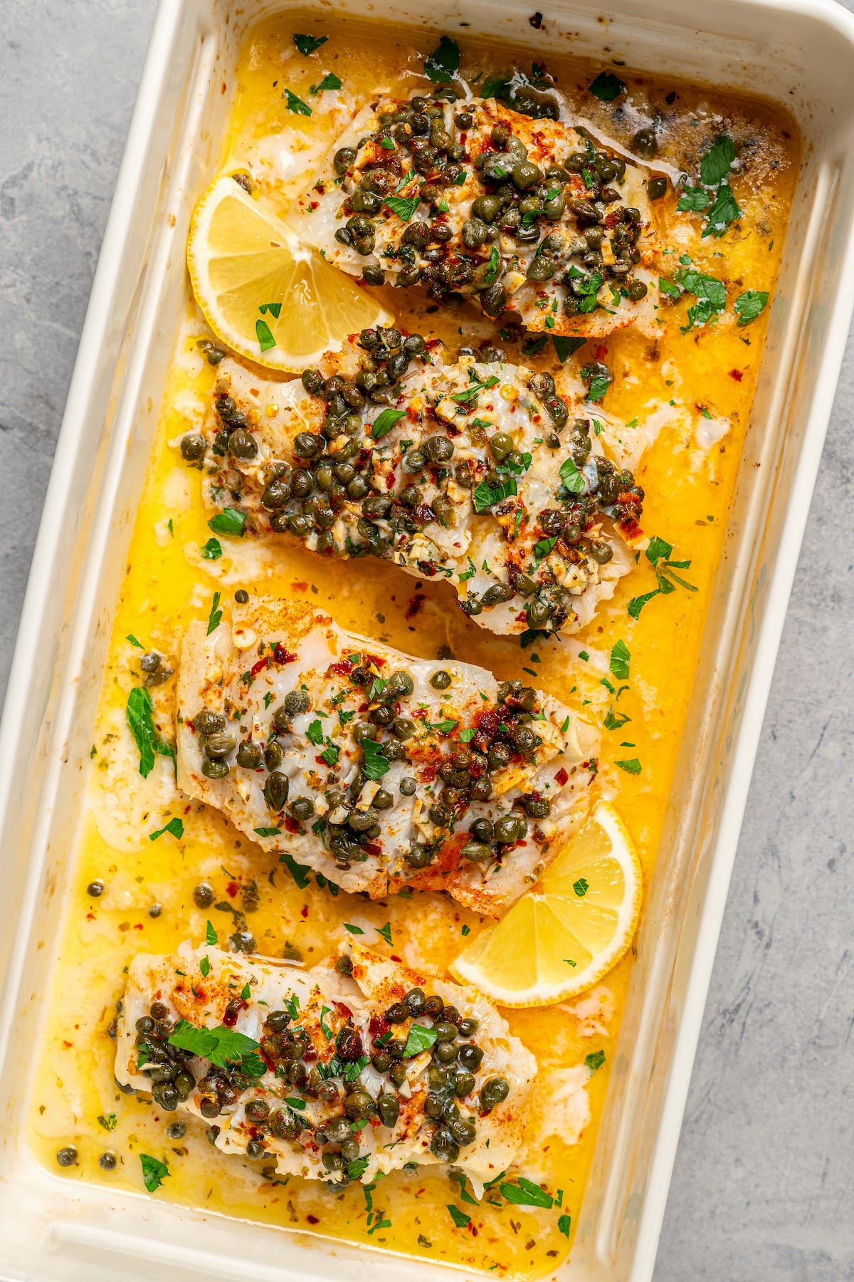 You'll crave the light, fresh flavors of this easy Baked Cod Recipe. Simple prep, perfect texture, and zingy flavor - what could be better? Pieces of fish baked in a dish with butter and seasonings.
