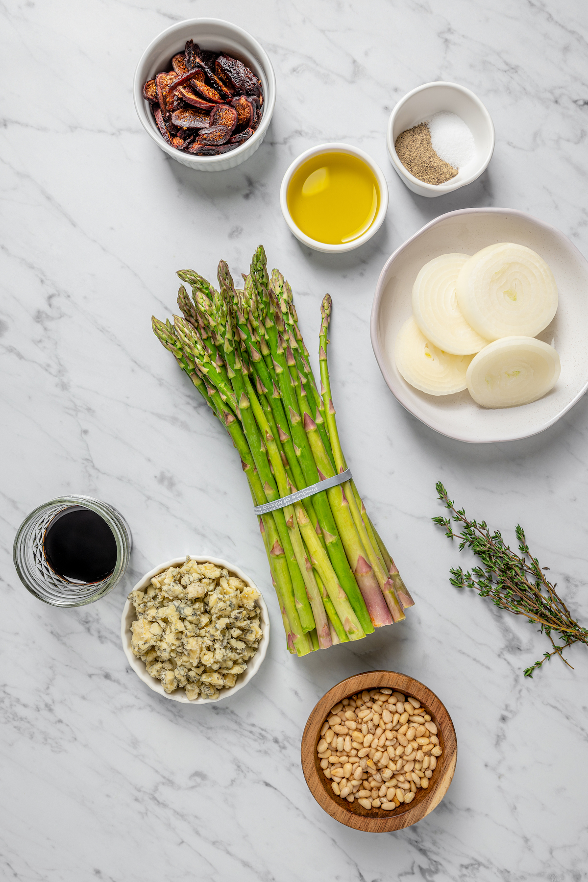 Grilled Asparagus with Onion recipe is topped with simple vinaigrette, blue cheese, black Mission figs, and toasted pine nuts. So flavorful! From top: Figs, olive oil, salt and pepper, onion, thyme, pine nuts, blue cheese, balsamic vinegar, asparagus.