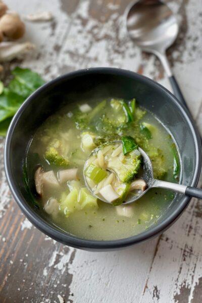 GREEN MUSHROOM ORZO SOUP in a bowl with spoon.