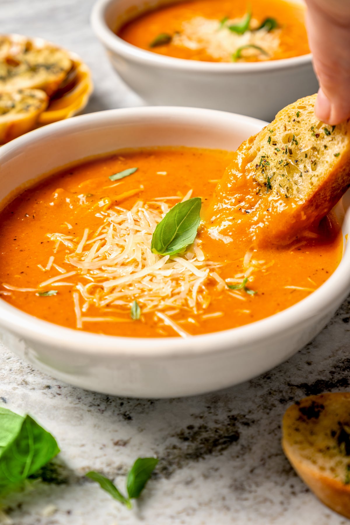 This easy tomato bisque recipe with parmesan and Italian seasoning is a comforting weeknight dinner paired with toasty sliced bread. Dipping a slice of bread into the soup.